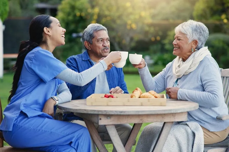 A peaceful garden scene at a senior care home, showcasing residents enjoying the outdoors amidst blooming plants.