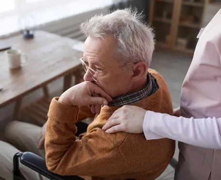 Senior man receiving compassionate support from a caregiver in assisted living