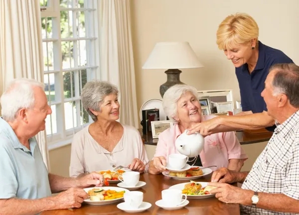 Caregiver serving nutritious food to elderly residents in a senior living community