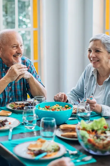 Senior couple enjoying a healthy meal together in an assisted living community dining area.