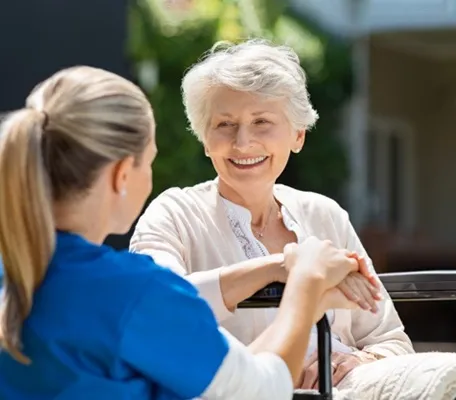 Senior woman enjoying conversation with caregiver at a senior living facility